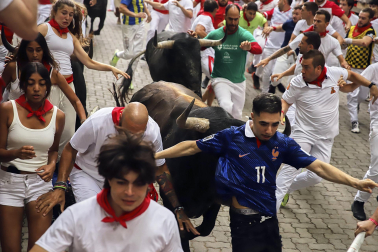 Fotos del séptimo encierro de San Fermín 2026 con toros de Miura en la bajada al callejón.