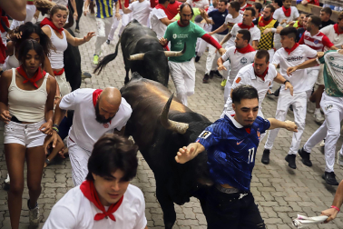 Fotos del séptimo encierro de San Fermín 2026 con toros de Miura en la bajada al callejón.