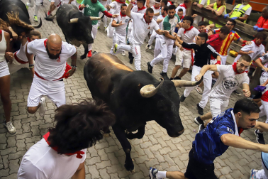 Fotos del séptimo encierro de San Fermín 2026 con toros de Miura en la bajada al callejón.