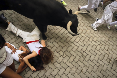Fotos del séptimo encierro de San Fermín 2026 con toros de Miura en la bajada al callejón.
