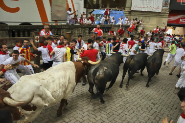 Fotos del séptimo encierro de San Fermín 2026 con toros de Miura en la bajada al callejón.