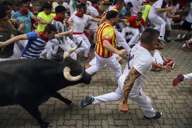 Fotos del séptimo encierro de San Fermín 2026 con toros de Miura en la bajada al callejón.