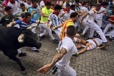 Fotos del séptimo encierro de San Fermín 2026 con toros de Miura en la bajada al callejón.