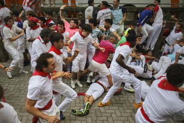 Fotos del séptimo encierro de San Fermín 2026 con toros de Miura en la bajada al callejón.