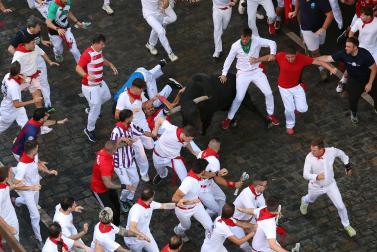 Fotos del octavo encierro de San Fermín 2026 con toros de la ganadería de Jandilla en la bajada al callejón.