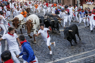 Fotos del octavo encierro de San Fermín 2026 con toros de la ganadería de Jandilla en la curva de Mercaderes.