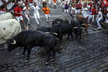 Fotos del octavo encierro de San Fermín 2026 con toros de la ganadería de Jandilla en la curva de Mercaderes.