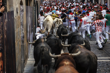 Fotos del octavo encierro de San Fermín 2026 con toros de la ganadería de Jandilla en la curva de Mercaderes.