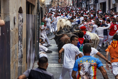 Fotos del octavo encierro de San Fermín 2026 con toros de la ganadería de Jandilla en la curva de Mercaderes.