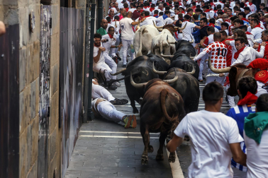 Fotos del octavo encierro de San Fermín 2026 con toros de la ganadería de Jandilla en la curva de Mercaderes.