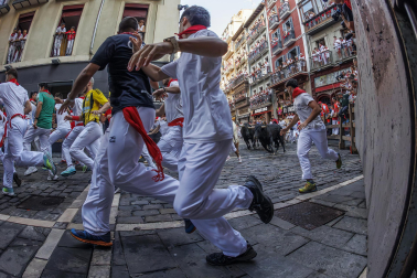 Fotos del octavo encierro de San Fermín 2026 con toros de la ganadería de Jandilla en la curva de Mercaderes.