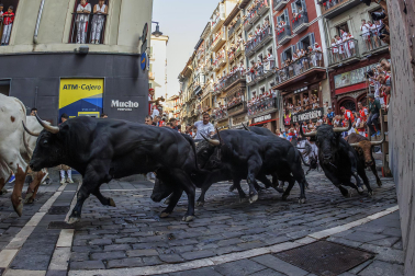 Fotos del octavo encierro de San Fermín 2026 con toros de la ganadería de Jandilla en la curva de Mercaderes.