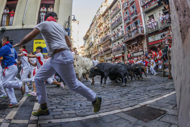 Fotos del octavo encierro de San Fermín 2026 con toros de la ganadería de Jandilla en la curva de Mercaderes.