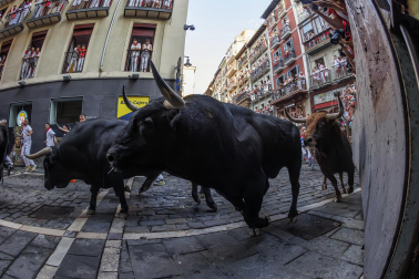 Fotos del octavo encierro de San Fermín 2026 con toros de la ganadería de Jandilla en la curva de Mercaderes.