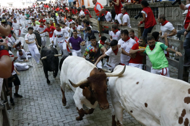 Fotos del octavo encierro de San Fermín 2026 con toros de la ganadería de Jandilla en la bajada al callejón.