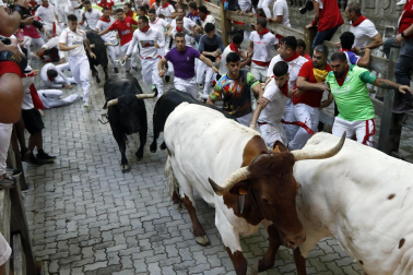Fotos del octavo encierro de San Fermín 2026 con toros de la ganadería de Jandilla en la bajada al callejón.