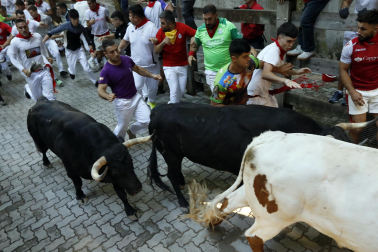Fotos del octavo encierro de San Fermín 2026 con toros de la ganadería de Jandilla en la bajada al callejón.