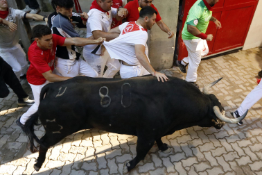 Fotos del octavo encierro de San Fermín 2026 con toros de la ganadería de Jandilla en la bajada al callejón.