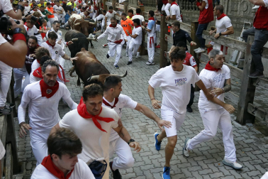 Fotos del octavo encierro de San Fermín 2026 con toros de la ganadería de Jandilla en la bajada al callejón.