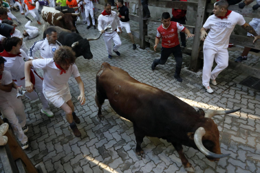 Fotos del octavo encierro de San Fermín 2026 con toros de la ganadería de Jandilla en la bajada al callejón.