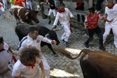 Fotos del octavo encierro de San Fermín 2026 con toros de la ganadería de Jandilla en la bajada al callejón.