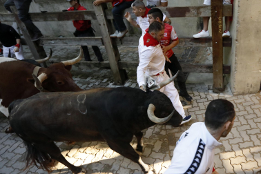 Fotos del octavo encierro de San Fermín 2026 con toros de la ganadería de Jandilla en la bajada al callejón.