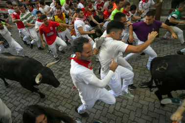 Fotos del octavo encierro de San Fermín 2026 con toros de la ganadería de Jandilla en la bajada al callejón.