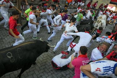 Fotos del octavo encierro de San Fermín 2026 con toros de la ganadería de Jandilla en la bajada al callejón.