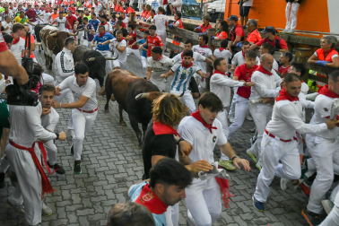 Fotos del octavo encierro de San Fermín 2026 con toros de la ganadería de Jandilla en la bajada al callejón.