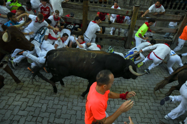 Fotos del octavo encierro de San Fermín 2026 con toros de la ganadería de Jandilla en la bajada al callejón.
