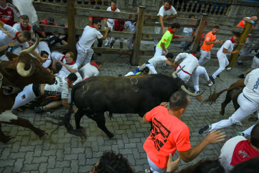 Fotos del octavo encierro de San Fermín 2026 con toros de la ganadería de Jandilla en la bajada al callejón.
