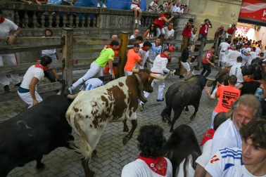 Fotos del octavo encierro de San Fermín 2026 con toros de la ganadería de Jandilla en la bajada al callejón.