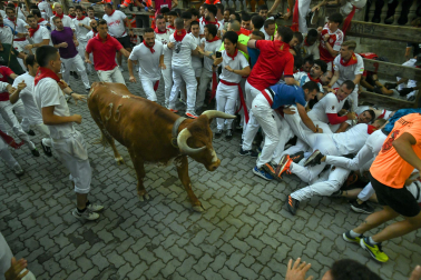 Fotos del octavo encierro de San Fermín 2026 con toros de la ganadería de Jandilla en la bajada al callejón.
