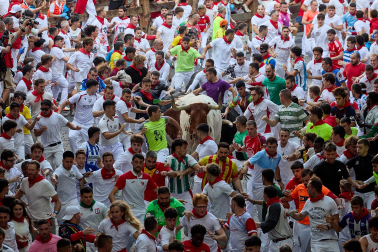 Fotos del octavo encierro de San Fermín 2026 con toros de la ganadería de Jandilla en la bajada al callejón.