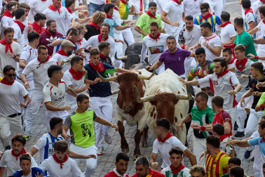 Fotos del octavo encierro de San Fermín 2026 con toros de la ganadería de Jandilla en la bajada al callejón.