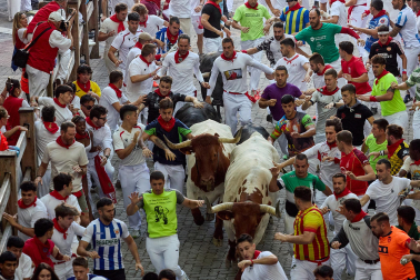 Fotos del octavo encierro de San Fermín 2026 con toros de la ganadería de Jandilla en la bajada al callejón.