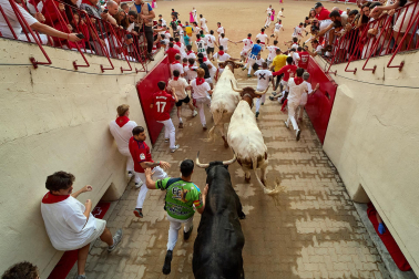 Fotos del octavo encierro de San Fermín 2026 con toros de la ganadería de Jandilla en la bajada al callejón.