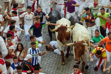Fotos del octavo encierro de San Fermín 2026 con toros de la ganadería de Jandilla en la bajada al callejón.