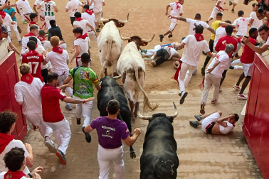 Fotos del octavo encierro de San Fermín 2026 con toros de la ganadería de Jandilla en la bajada al callejón.