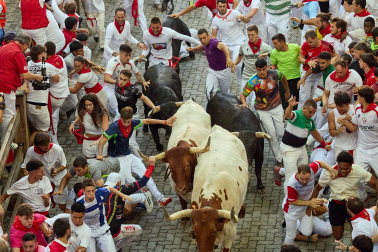 Fotos del octavo encierro de San Fermín 2026 con toros de la ganadería de Jandilla en la bajada al callejón.