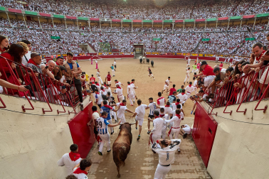 Fotos del octavo encierro de San Fermín 2026 con toros de la ganadería de Jandilla en la bajada al callejón.