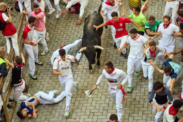 Fotos del octavo encierro de San Fermín 2026 con toros de la ganadería de Jandilla en la bajada al callejón.