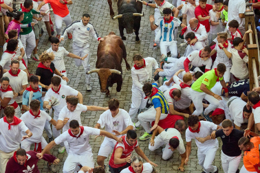 Fotos del octavo encierro de San Fermín 2026 con toros de la ganadería de Jandilla en la bajada al callejón.
