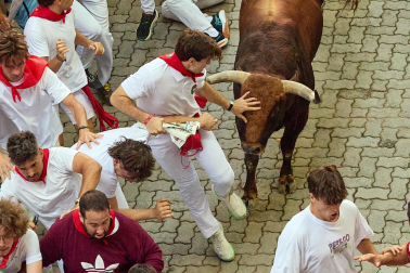 Fotos del octavo encierro de San Fermín 2026 con toros de la ganadería de Jandilla en la bajada al callejón.
