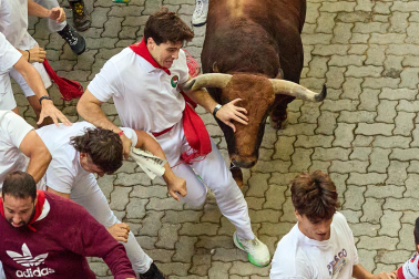 Fotos del octavo encierro de San Fermín 2026 con toros de la ganadería de Jandilla en la bajada al callejón.