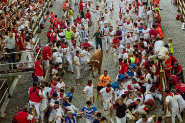 Fotos del octavo encierro de San Fermín 2026 con toros de la ganadería de Jandilla en la bajada al callejón.