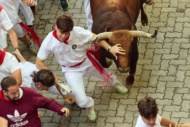 Fotos del octavo encierro de San Fermín 2026 con toros de la ganadería de Jandilla en la bajada al callejón.