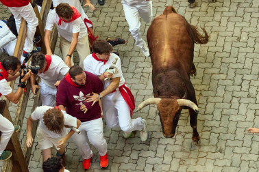 Fotos del octavo encierro de San Fermín 2026 con toros de la ganadería de Jandilla en la bajada al callejón.