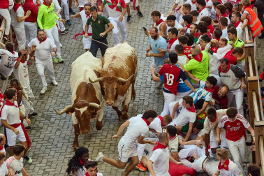 Fotos del octavo encierro de San Fermín 2026 con toros de la ganadería de Jandilla en la bajada al callejón.