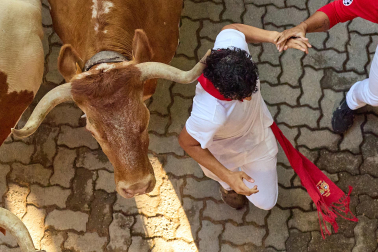 Fotos del octavo encierro de San Fermín 2026 con toros de la ganadería de Jandilla en la bajada al callejón.